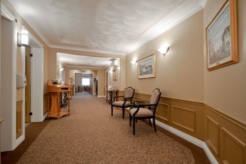 An interior hallway photo of Pilon Family Funeral Home showing comfortable seating and decorative hangings.